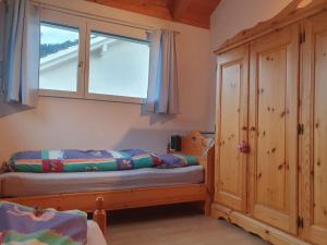 EmsCasa Nadja, nähe Skigebiet Flims-Lax的一间卧室设有一张床和一个窗口