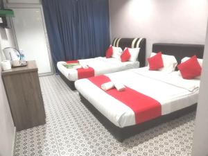 丹那拉打Ar Rayyan Hotel的两张位于酒店客房的床,配有红色和白色枕头