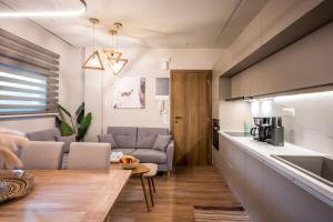 海若克利欧Amalia's Luxury Apartment 2的厨房以及带沙发和桌子的客厅。
