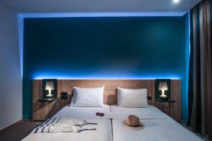 赫索尼索斯无限蓝精品酒店及Spa - 仅限成人的一间卧室配有一张蓝色墙壁的床