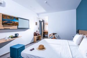 赫索尼索斯无限蓝精品酒店及Spa - 仅限成人的酒店客房,配有带帽子的床