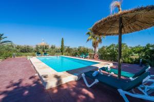 埃尔波特Ideal Property Mallorca - Rotes的一个带两把椅子和遮阳伞的游泳池