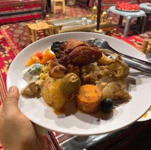 瓦迪拉姆Wadi Rum Story Camp的桌上一盘带肉和蔬菜的食物