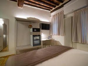 锡耶纳Torre del Fuggisole的一间卧室配有一张床,厨房配有炉灶