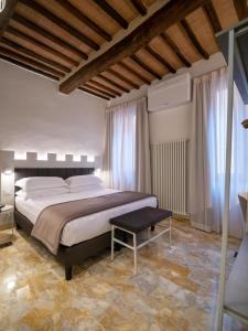 锡耶纳Torre del Fuggisole的一间卧室配有一张大床和一张桌子