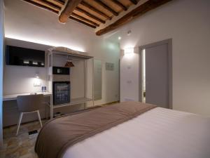 锡耶纳Torre del Fuggisole的一间带一张床和一张书桌的卧室和一间厨房