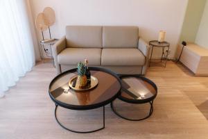 芒通新城堡公寓的客厅配有两张桌子和一张沙发