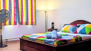 雅温得FIIAA的一间卧室配有一张色彩缤纷的床和灯