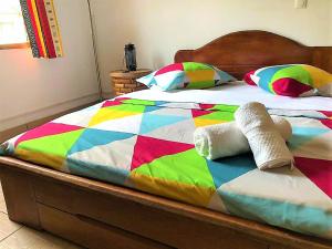 雅温得FIIAA的床上配有色彩缤纷的被子和枕头