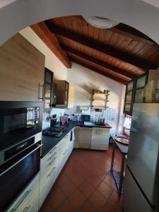 勒威诺Casa-Shila的一间大厨房,配有白色橱柜和黑色家电