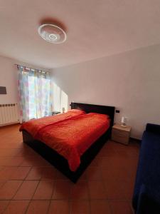 勒威诺Casa-Shila的一间卧室配有一张带红色棉被的床和窗户。