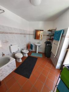 勒威诺Casa-Shila的带浴缸、卫生间和盥洗盆的浴室