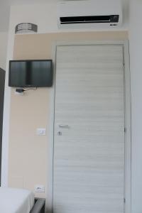 米兰Gambara GuestS House的卧室旁边的墙上有电视的门