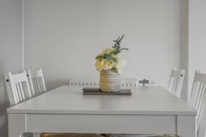 伦敦Centrally Located Modern 2Bed 2Bath Apartment的花瓶上的白色桌子
