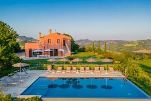 CossignanoRelais Tenuta Santori的别墅 - 带带椅子和遮阳伞的游泳池