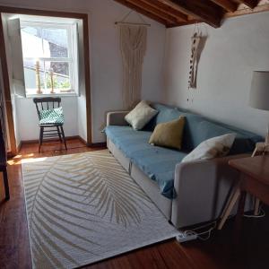 圣克鲁斯达格拉西奥萨Graciosa Family House的客厅设有蓝色的沙发和窗户。