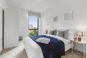 伦敦Centrally Located Modern 2Bed 2Bath Apartment的白色的卧室设有白色的床和窗户。