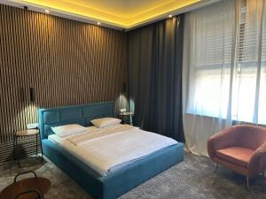 萨格勒布B&B Cvjetni的一间卧室配有蓝色的床和椅子