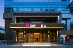 杭州ECHARM Plus Hotel - Hangzhou Binjiang Starlight Avenue的前面有标志的建筑