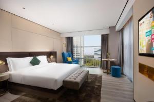 杭州ECHARM Plus Hotel - Hangzhou Binjiang Starlight Avenue的酒店客房设有一张床和一个大窗户