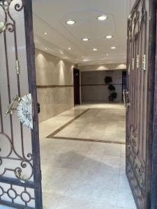 麦地那Taibah Apartment的走廊上设有1间铺有瓷砖地板的大客房