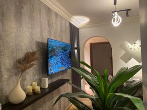 麦地那Taibah Apartment的客厅的墙上配有电视