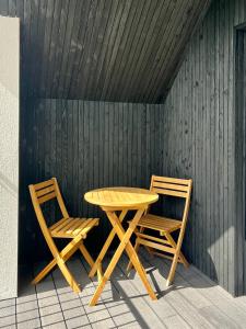 LlanymynechThe Loft Studio apartment - above detached new build garage的木墙旁的一张木桌和两把椅子