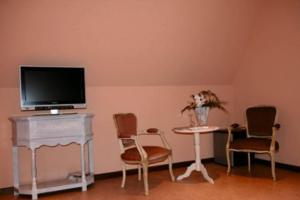 HertsbergeB&B Heerlijkhyd的客厅配有电视和桌椅