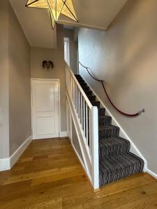 拉伊The Brontë Wing at The Apothecary Rye的走廊上设有吊灯的楼梯