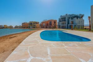 赫尔格达Apartment in Gouna Tawila The Butterfly的游泳池,位于水体旁的度假胜地