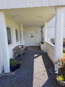 YtterlandLeilighet i enebolig på Valderøya ved Ålesund的长凳和植物的房子的门廊