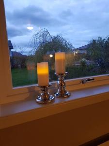 YtterlandLeilighet i enebolig på Valderøya ved Ålesund的两根蜡烛坐在窗前窗台上