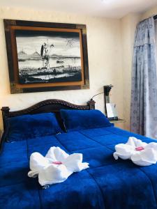 瓜塔佩Lake View Hostel的一张蓝色的床,上面有两朵白色的花