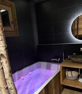 阿克1950Appartement style chalet 5* vue Mont-Blanc - Arc 1950的浴室内设有一个紫色照明浴缸