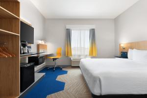 LachuteMicrotel Inn & Suites by Wyndham Lachute的配有一张床和一张书桌的酒店客房
