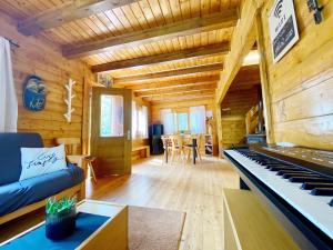 林瓜格洛萨Baita Nord的小木屋内带钢琴的客厅