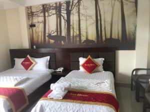 Lương KêHotel Nam Sơn的墙上画画的房间里设有两张床