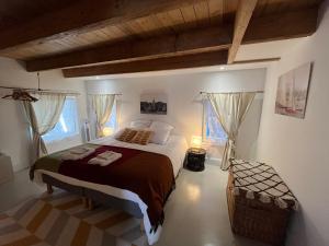 Saint-RogatienLE CLOS DE FLO 17的一间卧室设有一张大床和两个窗户。