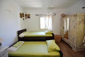 伊兹拉Nelly's Coastal Family House的一间卧室设有两张床和窗户。