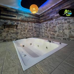 圣罗莎德卡瓦尔Finca Campestre Villa del Campo的带浴缸的浴室和石墙