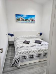 马斯帕洛马斯Chalet Luxury with privacy and Jacuzzi的一张位于白色房间的床,墙上挂着一幅画