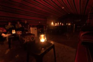 达纳Dana Sunset Eco Camp的一间暗室,配有一张桌子和蜡烛