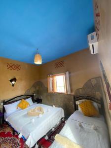 AgoudalAuberge Agoudal的卧室设有两张床,拥有蓝色的天花板