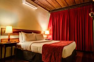 欧鲁普雷图普萨达阿尔坎若酒店的酒店客房,配有床和红色窗帘