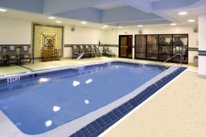 罗宾逊镇匹兹堡内维尔岛费尔菲尔德客栈&套房酒店的大型游泳池,位于带椅子的大房间
