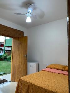 伊塔乌纳斯Pousada Luz da Vila Itaúnas的一间卧室配有一张床和吊扇