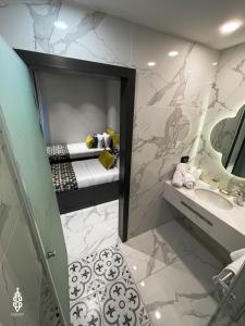 耶路撒冷Saladin Boutique Hotel的浴室设有床、水槽和镜子