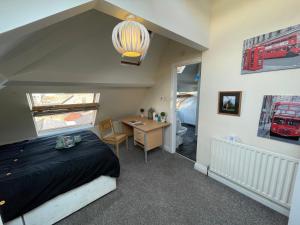 泰恩河畔纽卡斯尔Cosy Room in city centre的一间卧室配有一张床和一张书桌,另一间房间配有火车照片