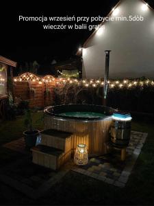 弗瓦迪斯瓦沃沃Domki Magnati的院子里的热水浴池,晚上有灯