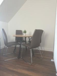 都柏林Modern design residence的一张桌子,上面有三把椅子和盆栽植物